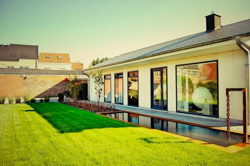 Waterpartij met cortenstalen rand langs de woning, cortenstalen frame met ketting en gazon — ‘80s spirit, Ternat