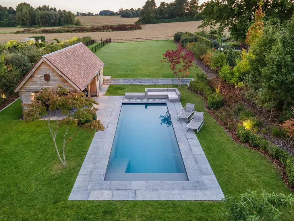 Zicht van bovenaf op zwembad, houten poolhouse, borders en velden — Klassieke tuin met zwembad, Roosdaal