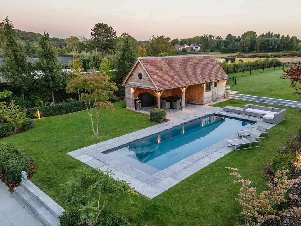 Houten poolhouse met pannendak en zwembad met ligbedden, van bovenaf gezien — Klassieke tuin met zwembad, Roosdaal