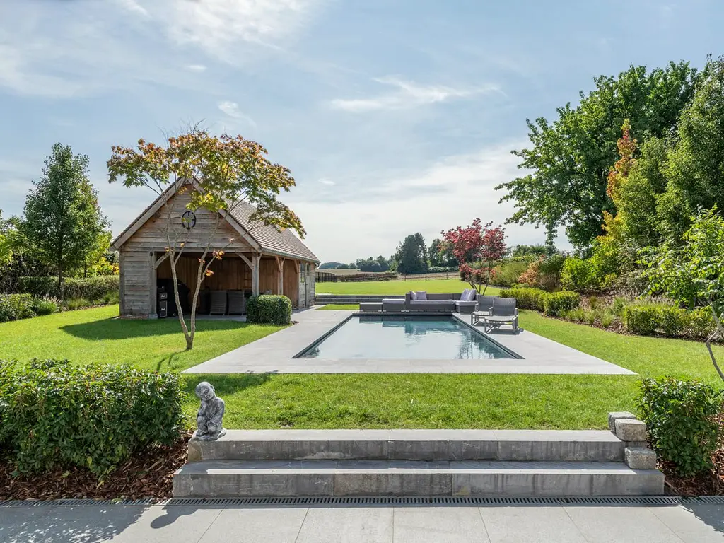Natuurstenen treden naar het gazon met zwembad en houten poolhouse — Klassieke tuin met zwembad, Roosdaal