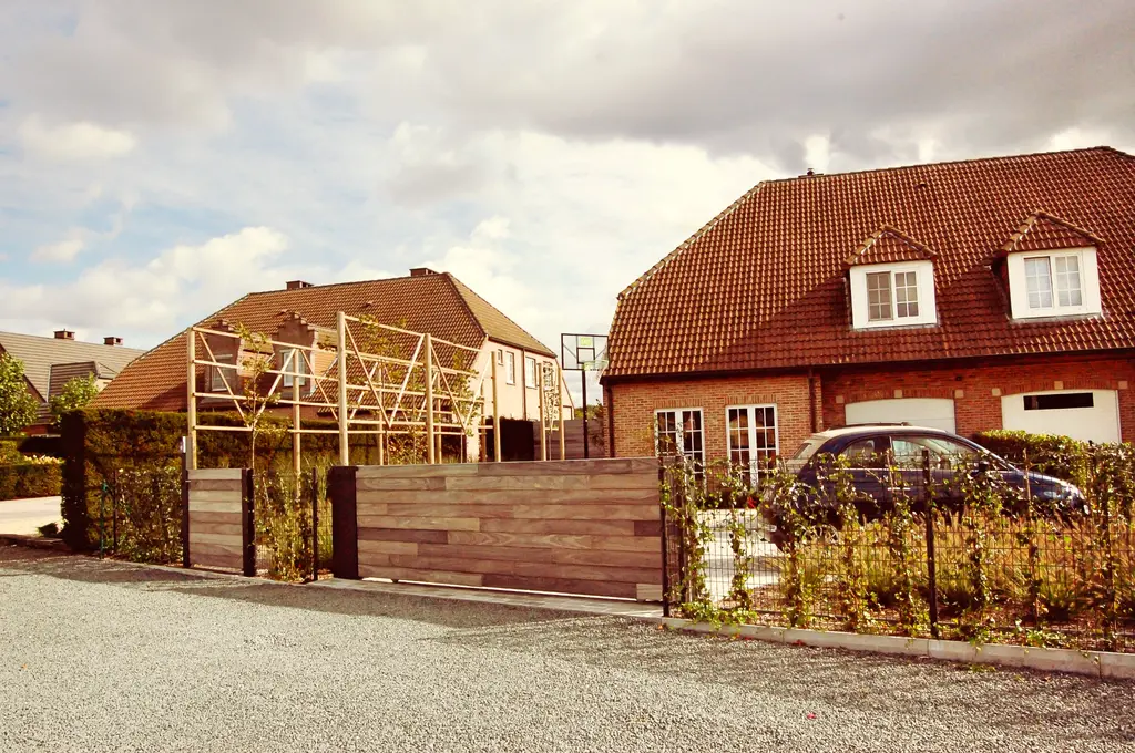 Voortuin met houten poort, draadafsluiting en leibomen aan houten frame, vanaf de straat — Klassieke voortuin
