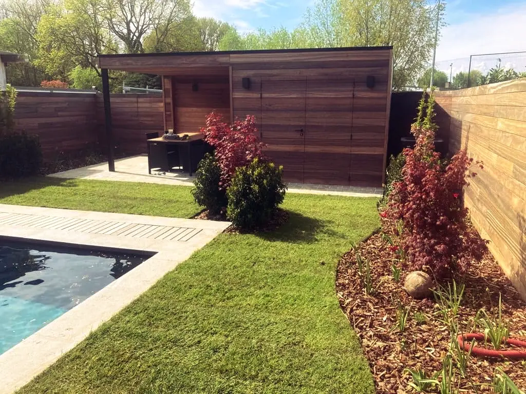 Houten poolhouse, hoek van het zwembad en gebogen border langs hoge houten schutting — Oase-tuin, Ternat