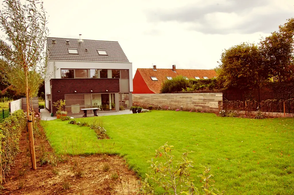 Ruim gazon met jonge bomen voor de moderne woning met terras en houten afscheiding — Open en toch gezellig