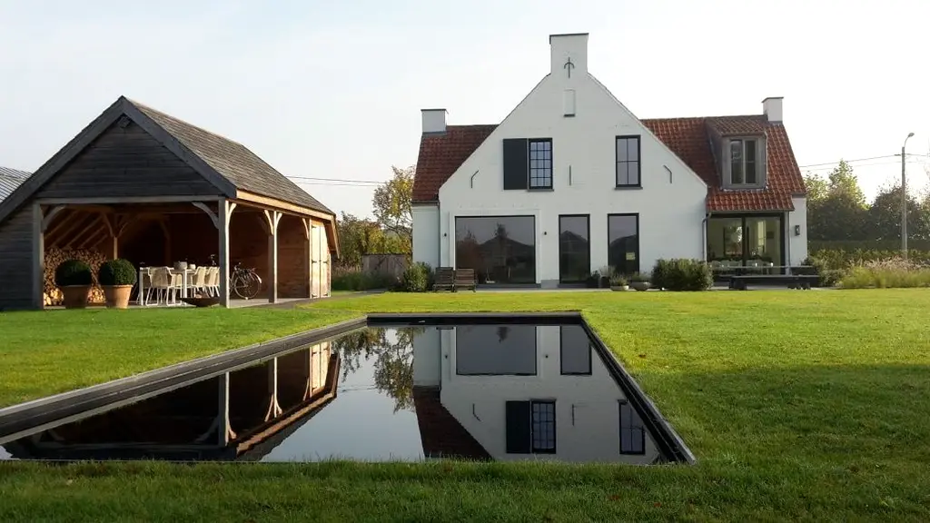 Rechthoekige waterspiegel in gazon met witte woning en houten overkapping — Sobere kwaliteit, Wolvertem