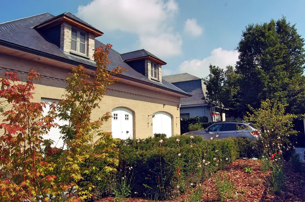 Voortuin met beplanting en boom in herfstkleur voor de woning — Uitnodigende tuin met buitenkeuken, Asse