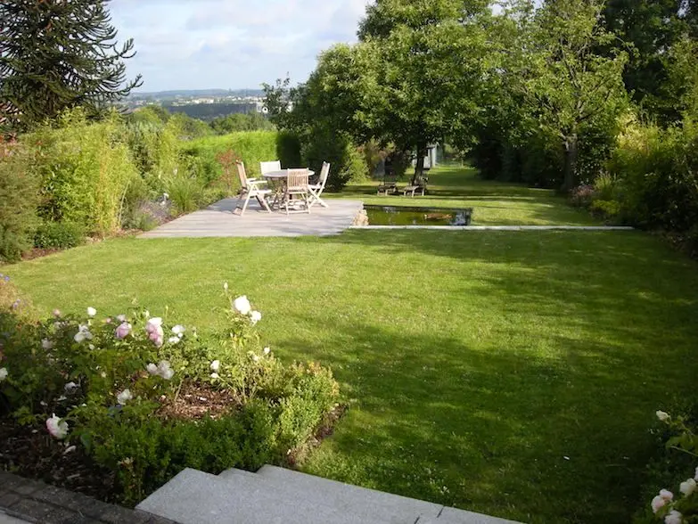 Gazon met rozenborder en houten terras met tafel en stoelen achteraan — Vijver in de kijker, Beersel