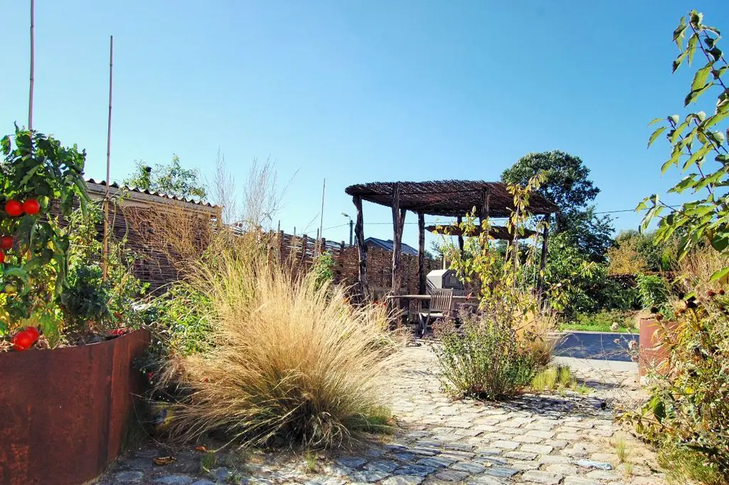 Kasseipad met siergras, cortenstalen plantenbak met tomaten en pergola — Wilde eetbare tuin, Sint-Pieters-Leeuw